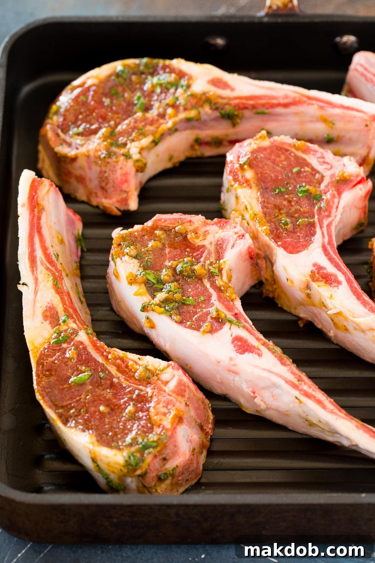 Flame-Kissed Lamb Chops 5 Meat in marinade on a grill pan, showing the chops ready for grilling.