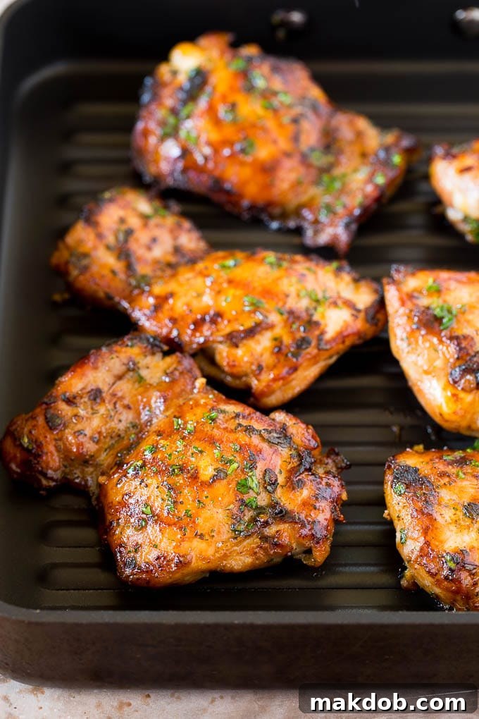 Perfectly grilled chicken thighs with a rich, herb-infused marinade. Chicken on a grill pan, with marinade creating a delicious crust.