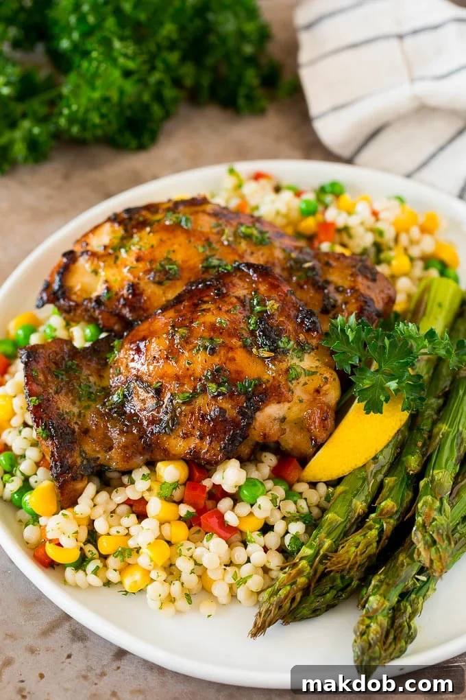 A wholesome meal featuring marinated chicken thighs, couscous, and asparagus. Marinated chicken thighs served with couscous and asparagus, a complete meal.