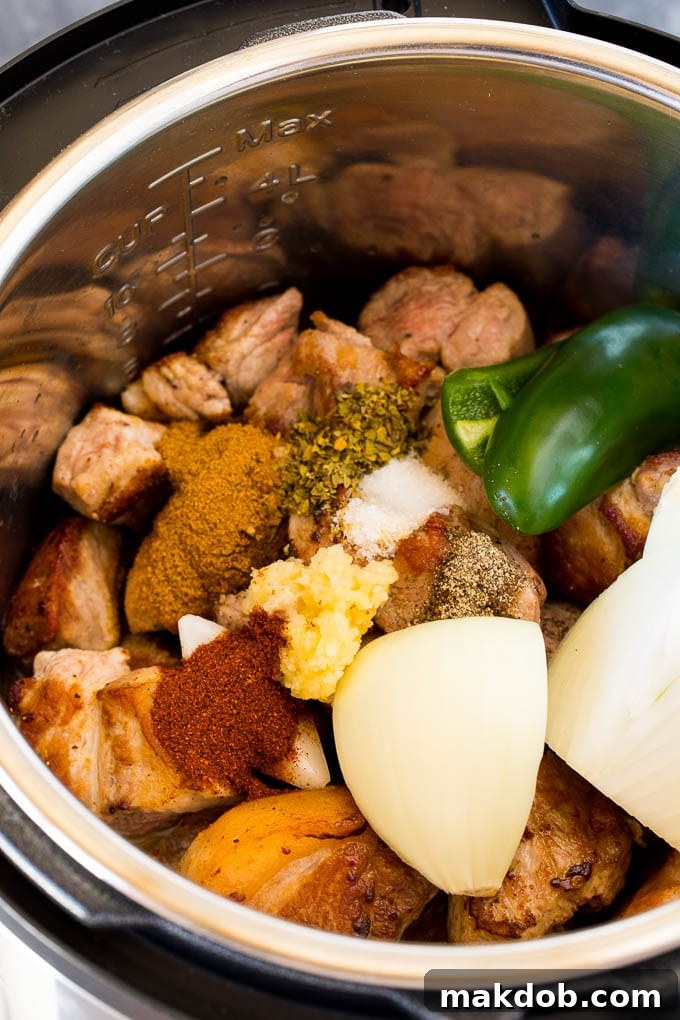 Pork, garlic, spices, jalapeno, and onion stewing in a pressure cooker, infused with rich flavors.