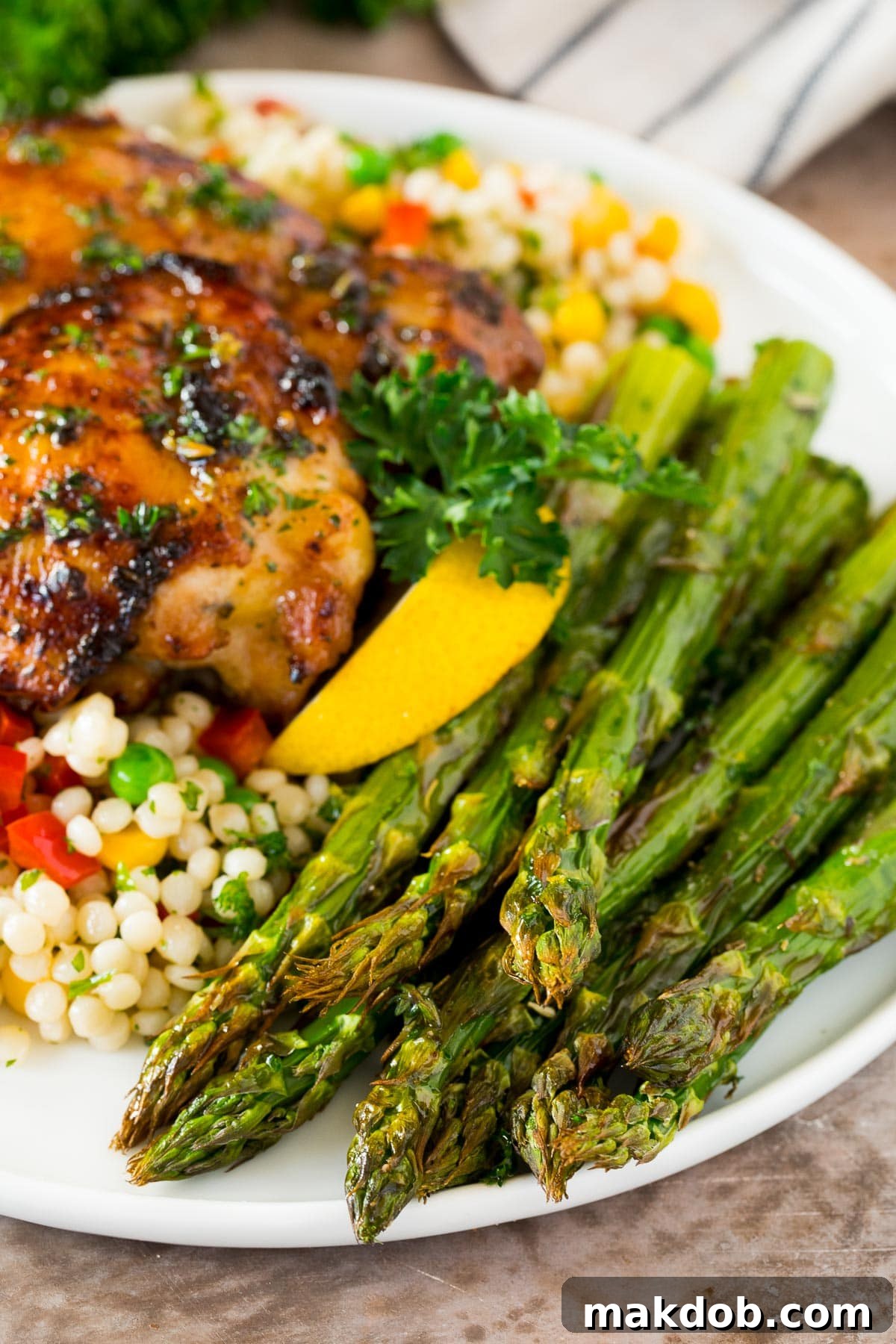 Air fryer asparagus served with chicken and couscous.