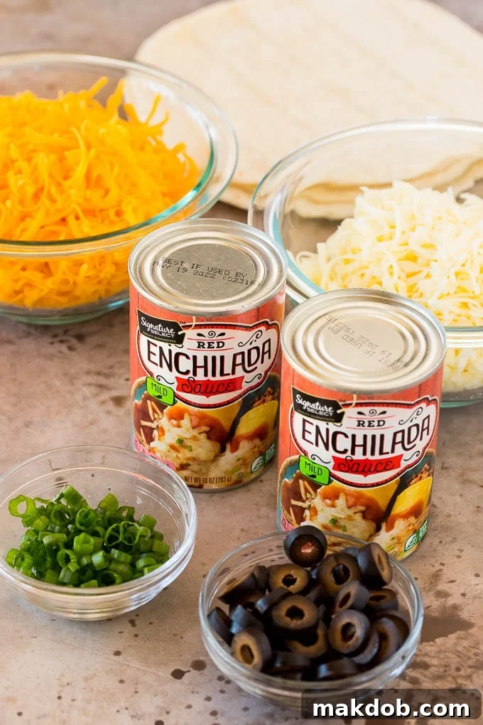 This recipe for cheese enchiladas is rolled flour tortillas filled with cheddar and Monterey Jack cheeses, then topped with red sauce and more cheese and baked to golden brown perfection. Cans of sauce and bowls of shredded cheese, green onions and olives.