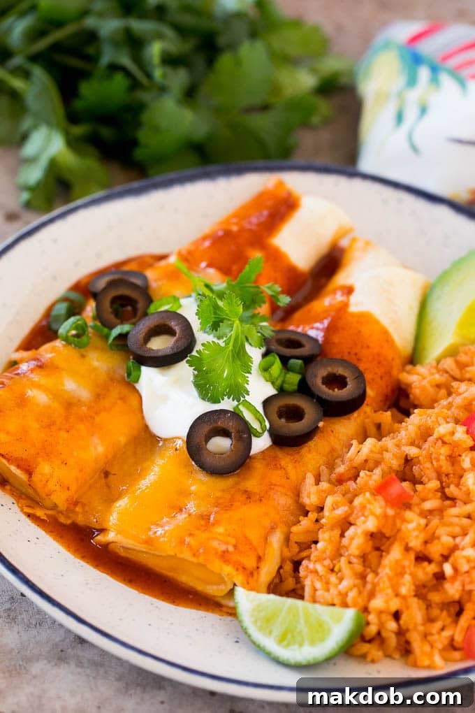 This recipe for cheese enchiladas is rolled flour tortillas filled with cheddar and Monterey Jack cheeses, then topped with red sauce and more cheese and baked to golden brown perfection. A plate of cheese enchiladas served with Mexican rice.
