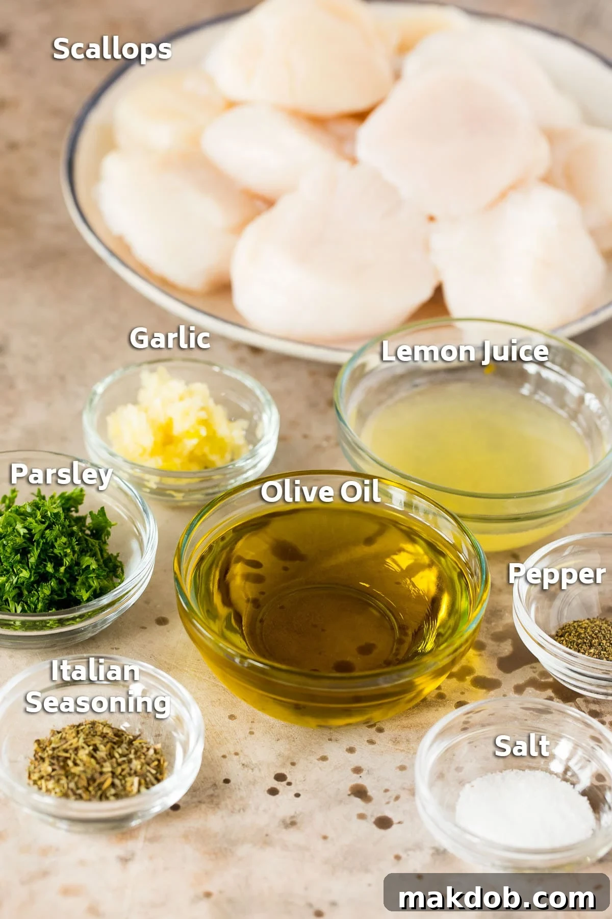 Bowls of marinade ingredients including olive oil, lemon, garlic, and herbs, arranged next to a plate of raw, clean sea scallops.