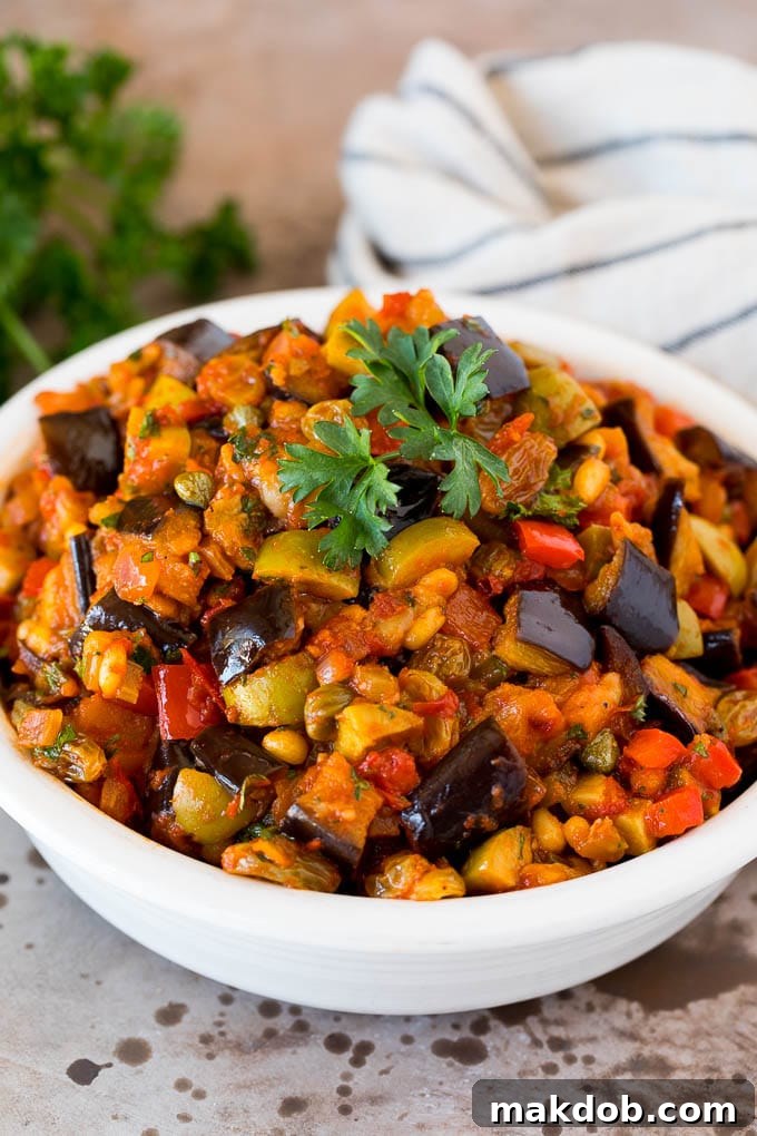 A beautifully garnished serving bowl of homemade caponata, topped with vibrant fresh parsley, ready to be enjoyed as a classic Italian appetizer or versatile side dish.