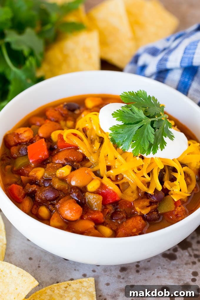 Delicious Vegetarian Chili with Cheese and Sour Cream A vibrant bowl of vegetarian chili, generously topped with shredded cheese and a dollop of sour cream, ready to be enjoyed.