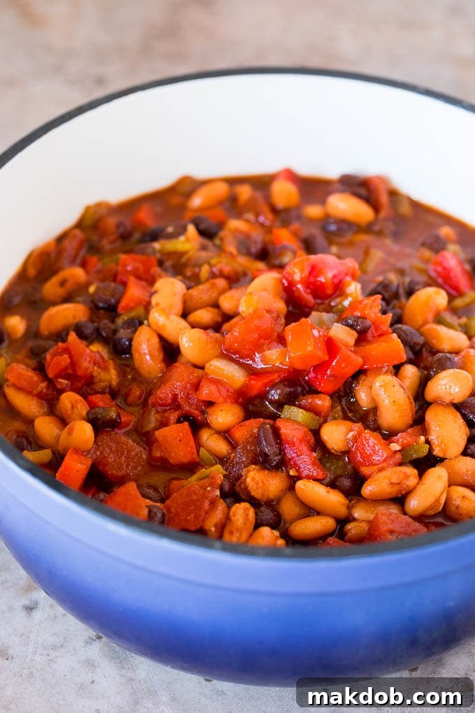 Vegetarian Chili Simmering in a Pot A hearty mix of colorful beans, vibrant bell peppers, diced onions, and rich tomatoes simmering together in a large soup pot, creating a flavorful vegetarian chili.