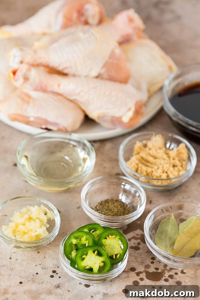 This chicken adobo is a Filipino dish made with chicken pieces simmered in a sweet and savory sauce. An easy dinner option with minimal ingredients that always gets rave reviews! Small bowls of ingredients including jalapenos, brown sugar, garlic and bay leaves.