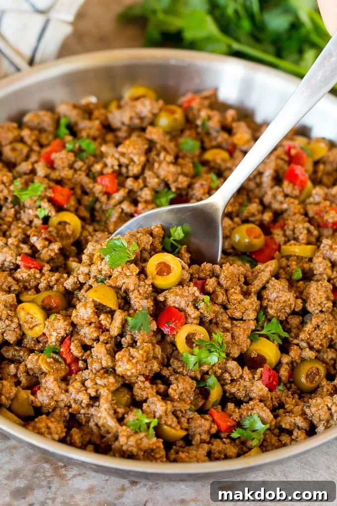A pan of picadillo with a serving spoon in it.