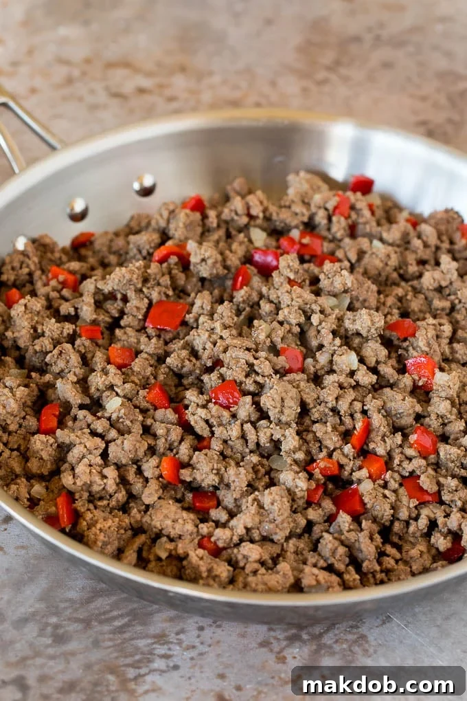 Ground beef and bell peppers in a skillet.