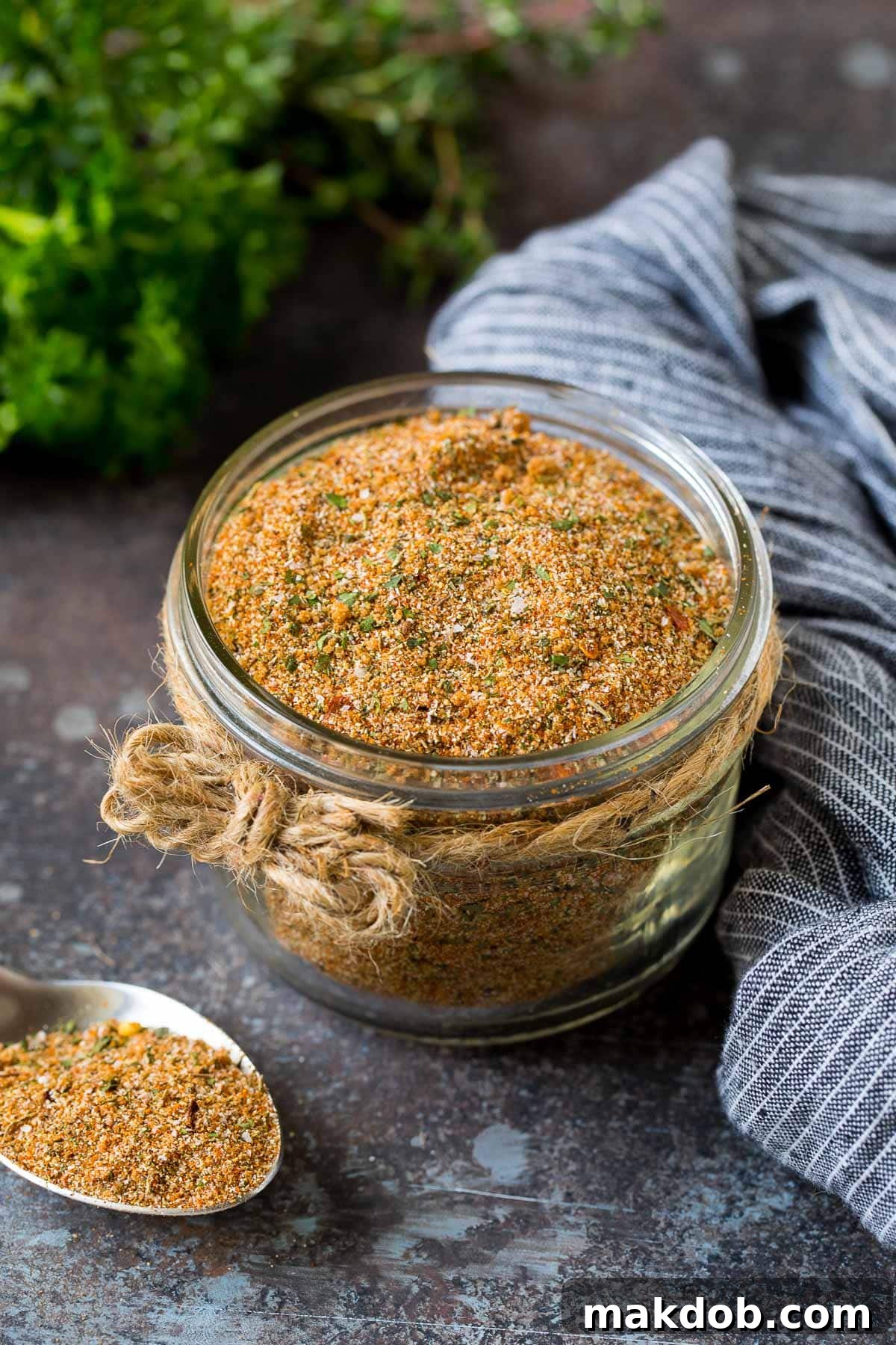 A jar of homemade Jamaican jerk seasoning surrounded by fresh herbs, vibrant and inviting, ready to infuse bold flavors.