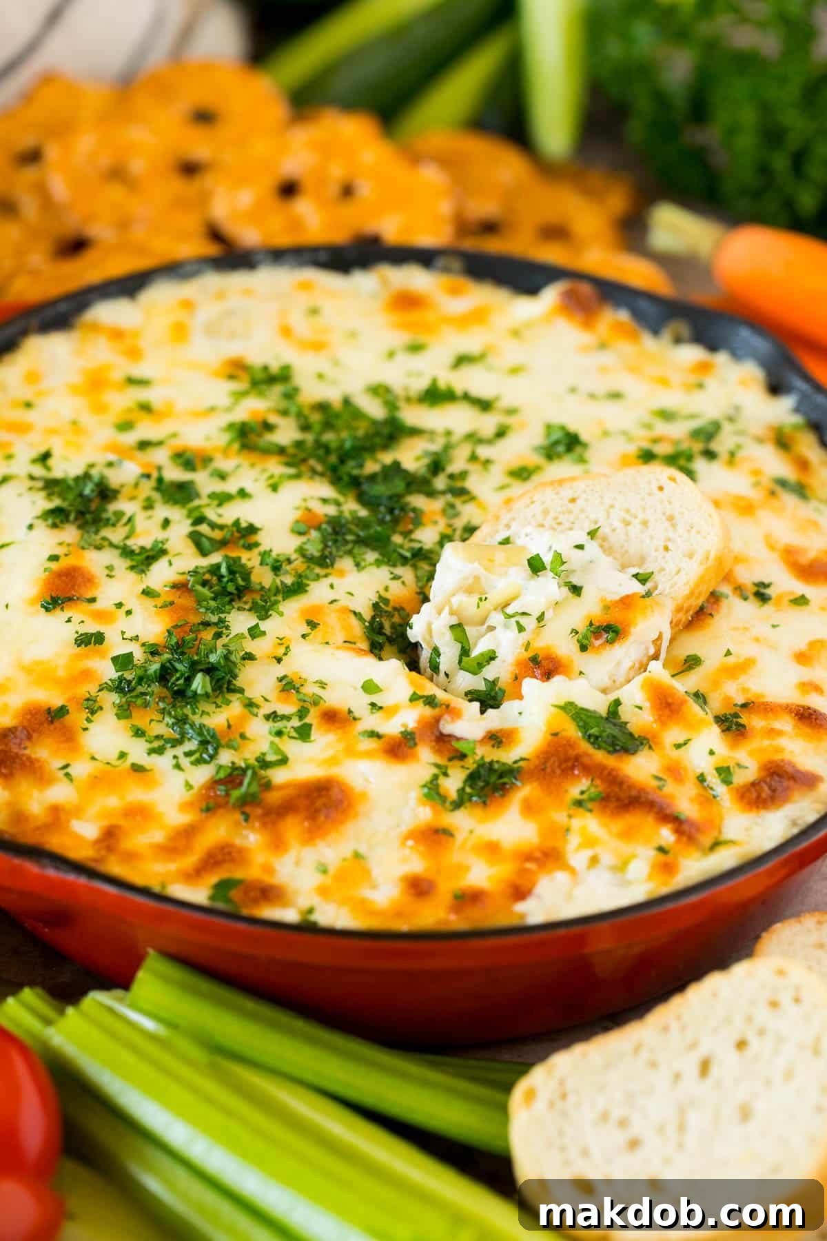 Irresistible Artichoke Dip 6 A slice of baguette in a pan full of artichoke dip.