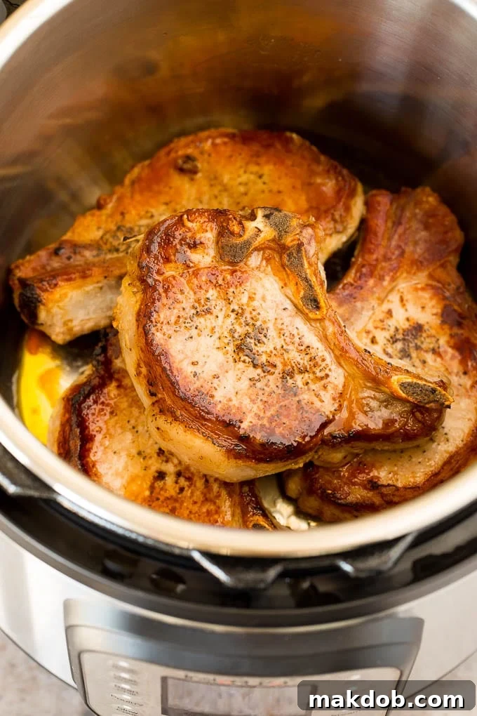 These Instant Pot pork chops are seared to golden brown perfection, then pressure cooked and covered in mushroom gravy. Seared pork chops in a pressure cooker.