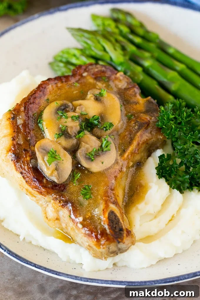 These Instant Pot pork chops are seared to golden brown perfection, then pressure cooked and covered in mushroom gravy. Instant Pot pork chops served over mashed potatoes with asparagus.