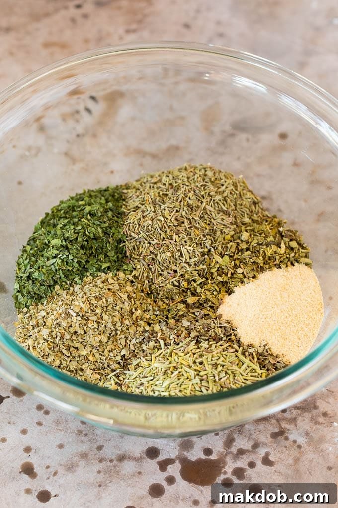 This homemade Italian seasoning is a blend of a variety of herbs and spices that creates a flavorful mix that can be used for so many different dishes. A mixing bowl with dried herbs and garlic powder in it.