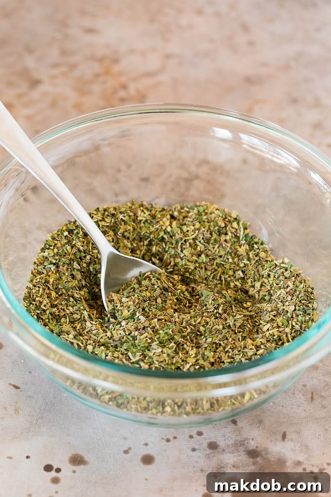 This homemade Italian seasoning is a blend of a variety of herbs and spices that creates a flavorful mix that can be used for so many different dishes. A bowl of seasoning blend with a spoon in it.