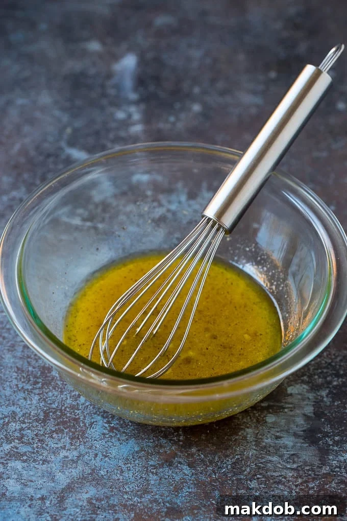 A bowl of homemade salad dressing with a whisk in it, ready to be poured.