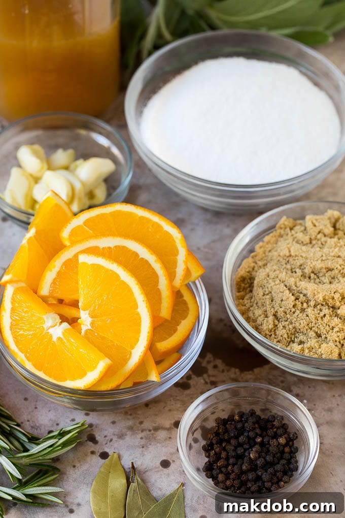 This is a complete guide on how to brine a turkey to get the most tender and flavorful bird each and every time. Various brine ingredients including orange slices, brown sugar, smashed garlic, and fresh herbs in separate bowls.