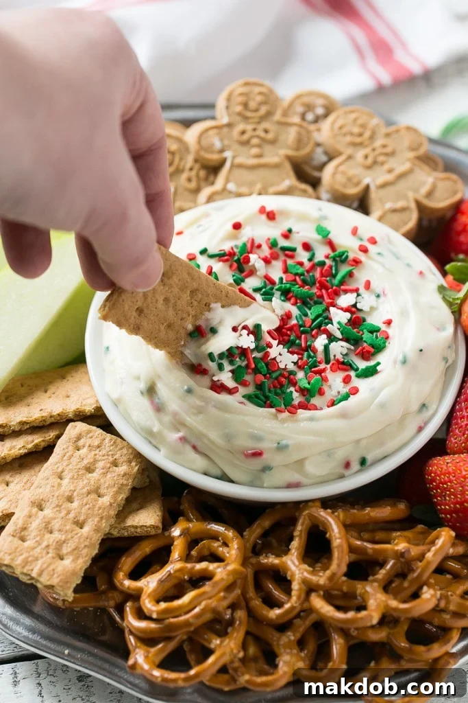 Magical Christmas Cookie Dough Dip 3 Close-up of a spoonful of creamy Christmas Cookie Dough Dip, showing its fluffy texture and colorful sprinkles, ready to be enjoyed.