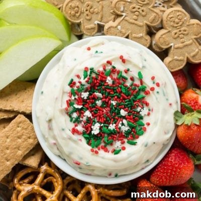 This Christmas cookie dough dip has a fluffy and creamy base that's swirled with plenty of holiday sprinkles and served with fruit and cookies for dipping. It only takes 5 minutes to make! #HolidayWithChobani Ad