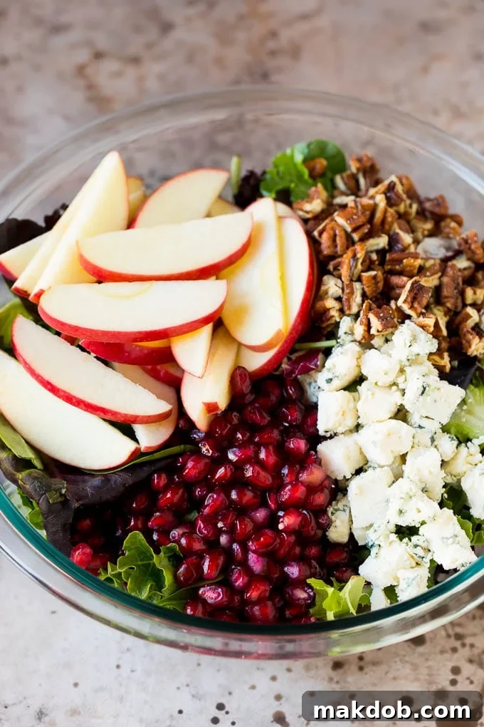 Lettuce topped with apples, blue cheese, pecans and pomegranate seeds.