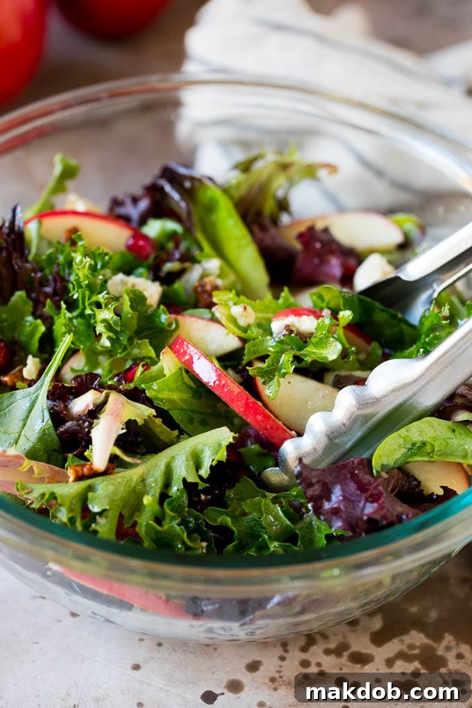 Tongs serving up a portion of Thanksgiving salad.