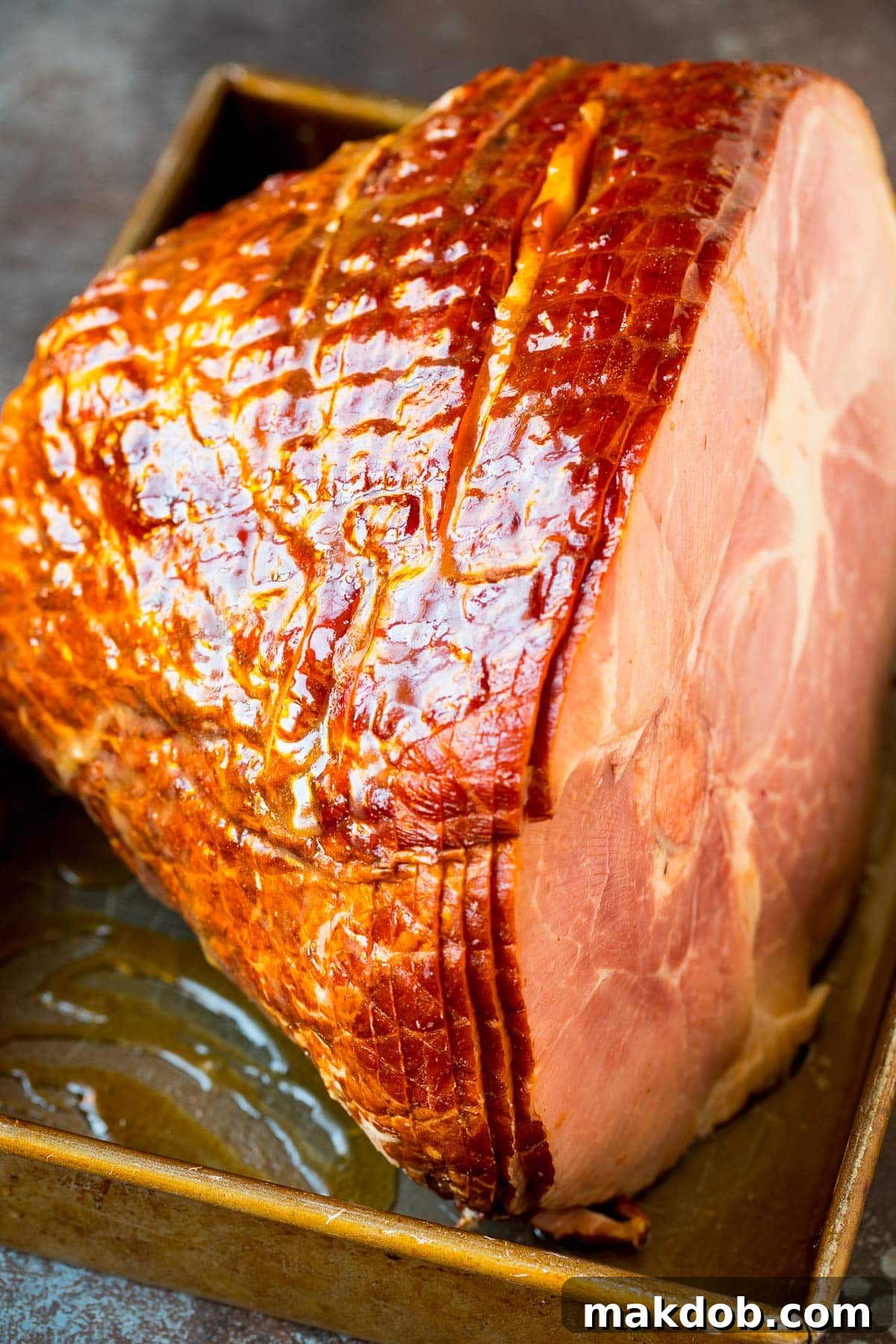 A juicy spiral ham nestled in a baking dish, glistening with homemade brown sugar glaze.