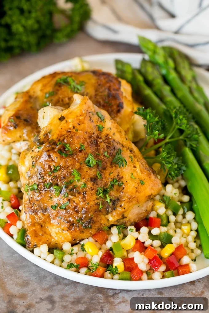 Instant Pot chicken thighs served over couscous with fresh herbs.