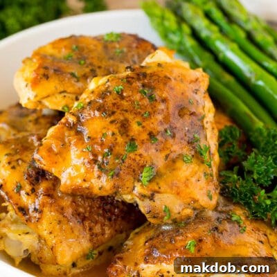 Instant Pot chicken thighs with gravy, served with asparagus.
