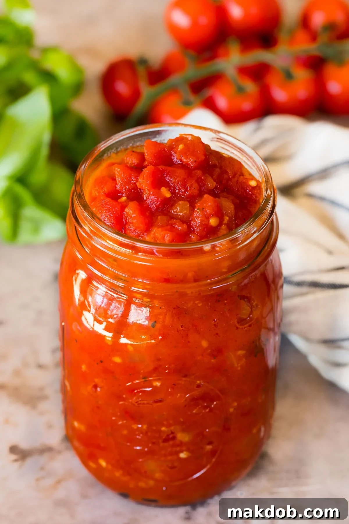 Robust Homemade Marinara 5 A beautiful jar of homemade marinara sauce, garnished with fresh basil, ready for storage or immediate use.