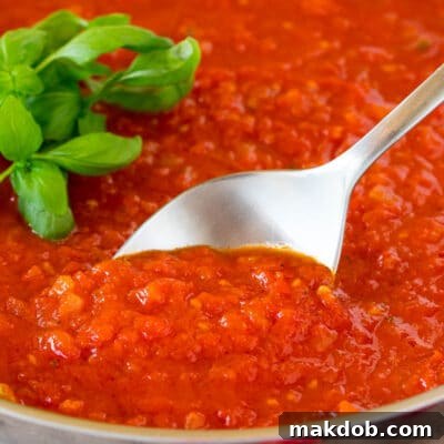 Robust Homemade Marinara 8 A serving spoon in a pan of homemade marinara sauce.