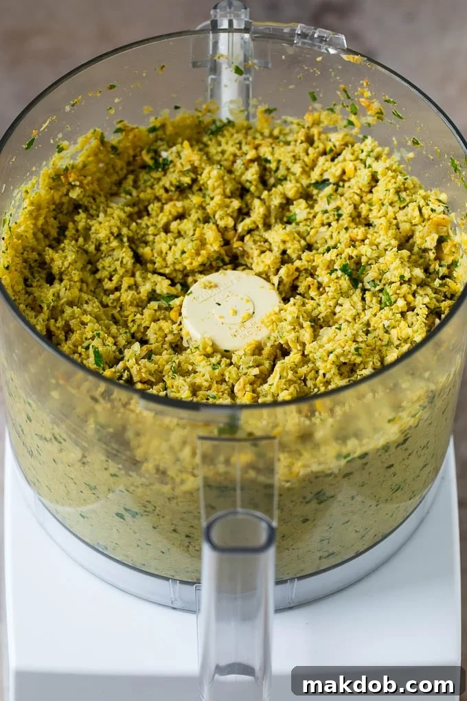 The ground mixture of chickpeas, herbs, and spices resting in the bowl of a food processor, perfectly textured and ready to be formed into falafel patties.