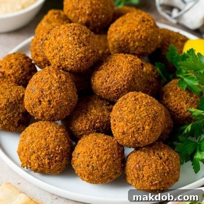 A platter of falafel garnished with parsley and lemon.