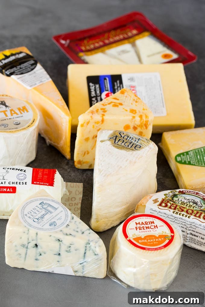 A guide to creating the best cheese board with a variety of different cheeses, crackers, fruit and accompaniments. Different cheeses wrapped in plastic, ready for assembly.