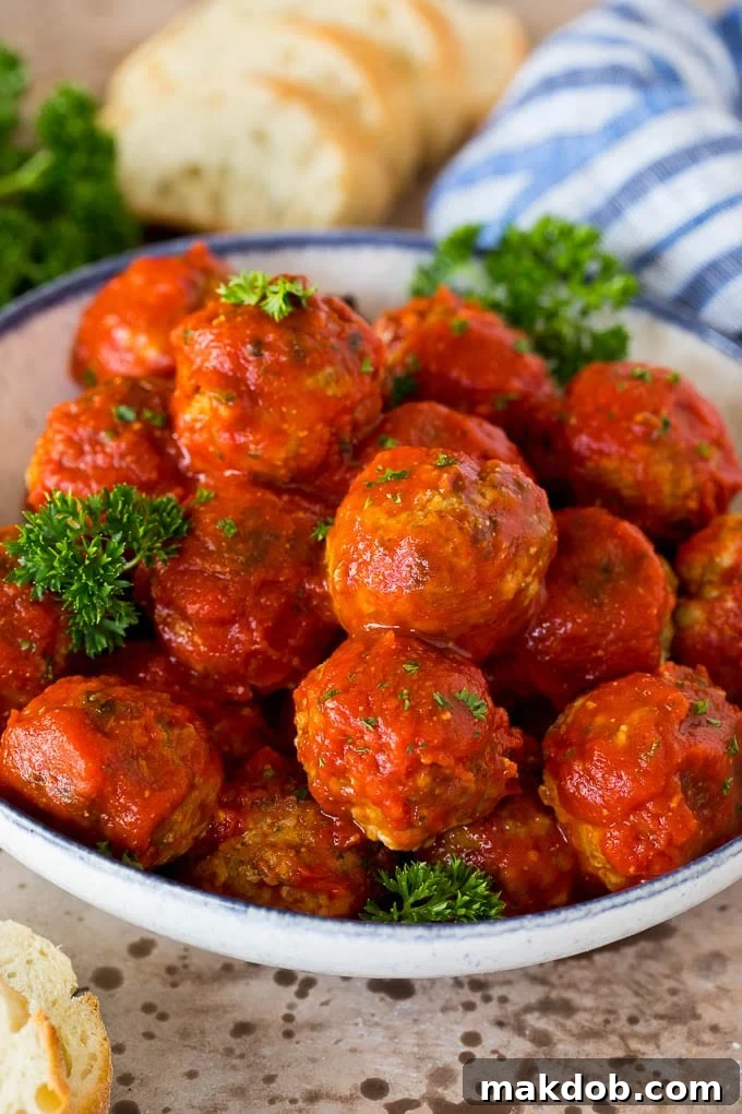 A bowl of Italian meatballs in rich tomato sauce, garnished with fresh parsley.