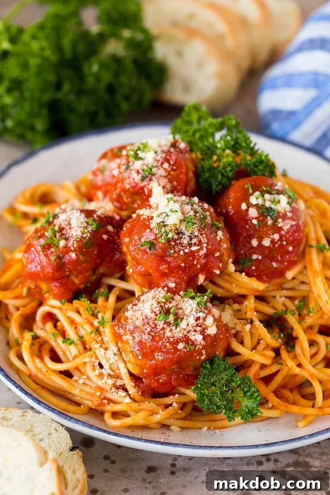 Classic Italian meatballs served generously over a bed of spaghetti, garnished with fresh basil.