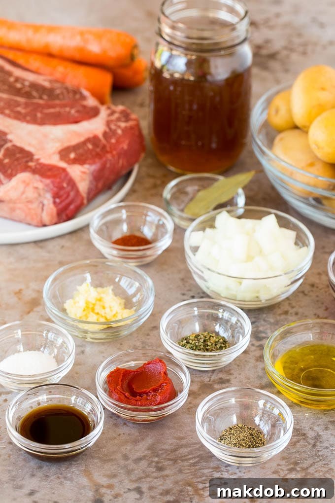 Ingredients for Instant Pot pot roast, including a beef chuck roast, carrots, potatoes, onion, garlic, red wine, beef broth, and various seasonings.