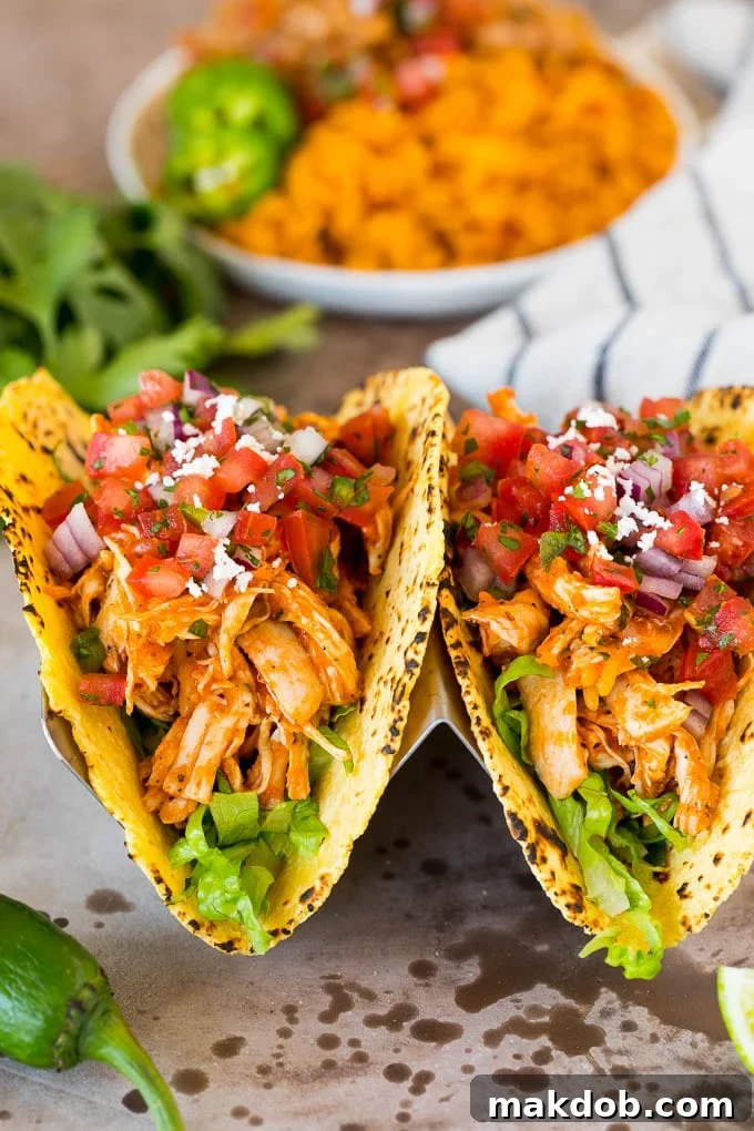 This chicken tinga is a classic dish made with shredded chicken that's simmered in a smoky and savory sauce. Chicken tinga tacos with lettuce and pico de gallo.