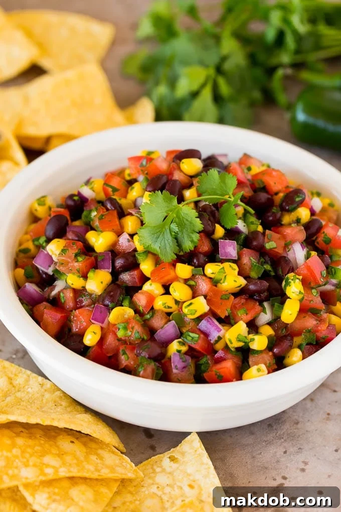 A bowl of black bean and corn salsa with tortilla chips.