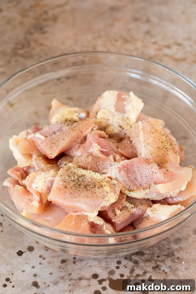 Chicken thighs, perfectly seasoned and diced, awaiting their transformation into a delicious teriyaki meal. Diced boneless, skinless chicken thighs seasoned with salt and pepper, ready for cooking.
