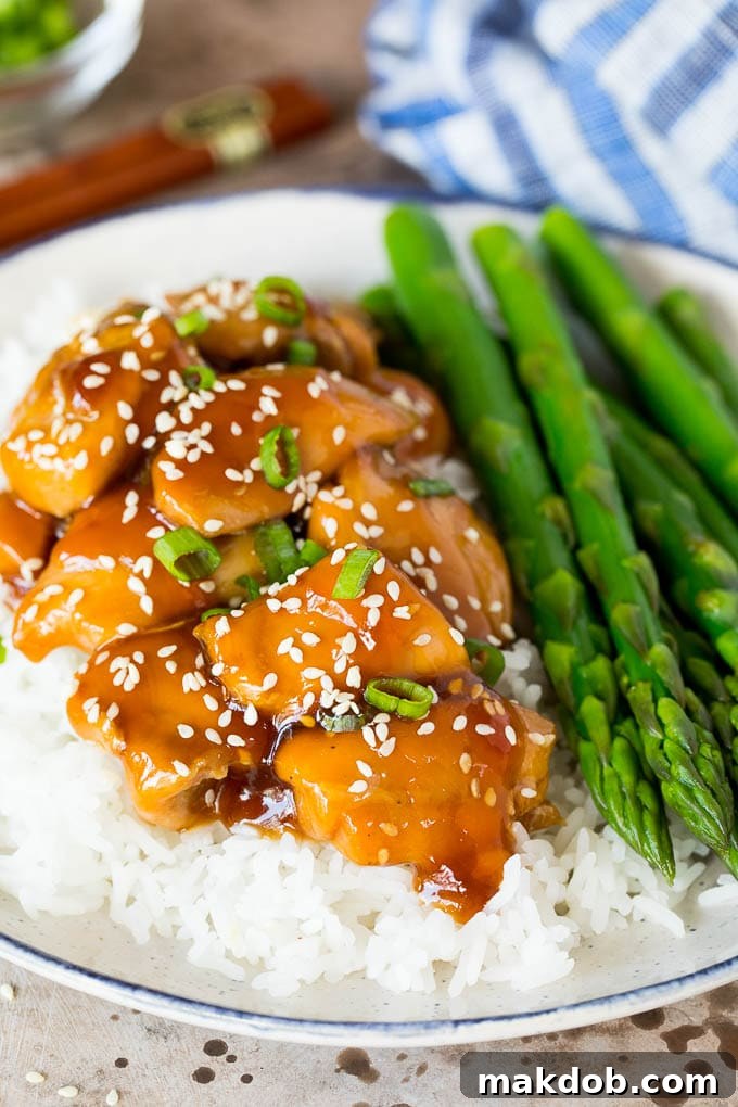 A perfectly portioned plate of Instant Pot teriyaki chicken, ready to be enjoyed. A plate of Instant Pot teriyaki chicken served over rice, garnished with green onions and sesame seeds.