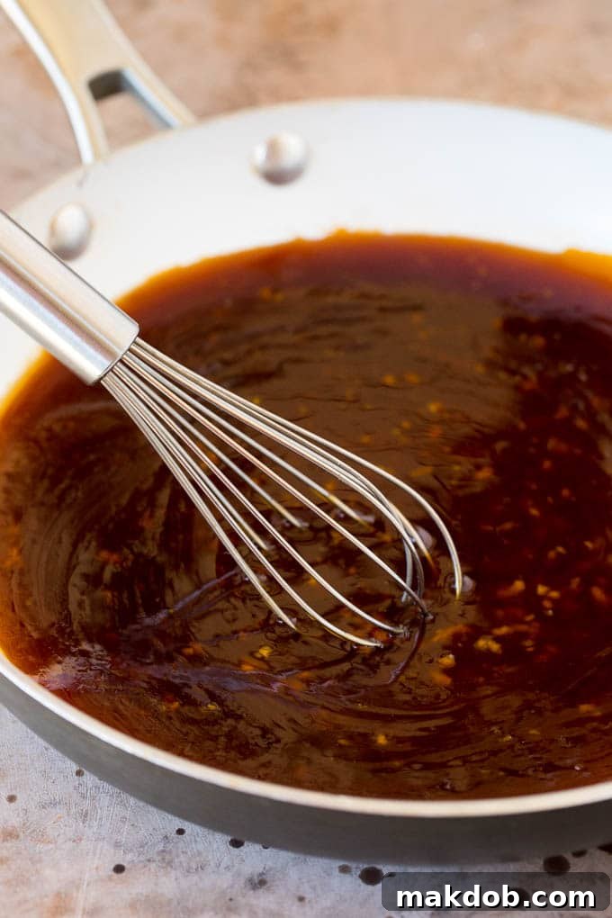 Perfectly Thick Homemade Teriyaki Sauce A whisk stirring a rich, glossy teriyaki sauce in a pan, highlighting its perfect, thick consistency.
