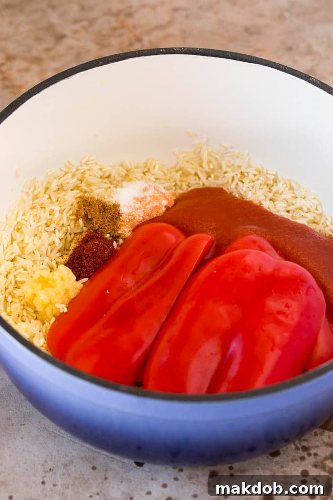 A pot of vibrant Mexican rice, infused with rich tomato sauce, aromatic spices, and a hint of bell pepper, ready to be covered and simmered.
