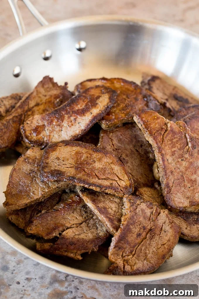 Sliced seared beef tenderloin, perfectly browned and ready to be added back to the stir-fry.
