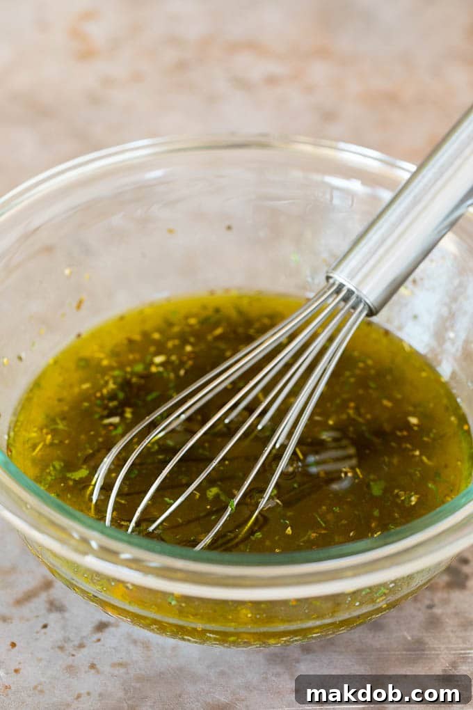 Homemade Italian Dressing Being Whisked A whisk stirring a freshly made bowl of homemade Italian dressing, showing its smooth consistency.