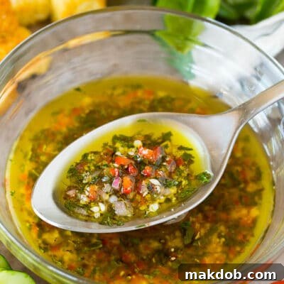 A bowl of homemade Italian dressing with a spoon in it.