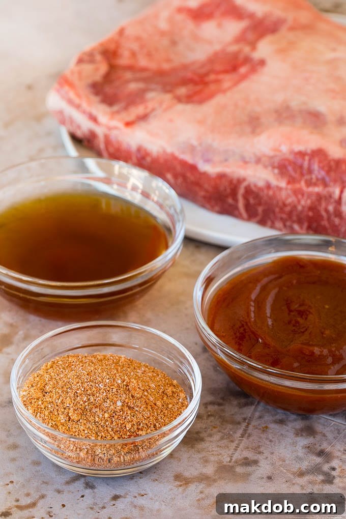 Raw brisket with bowls of beef broth, sauce and seasoning.