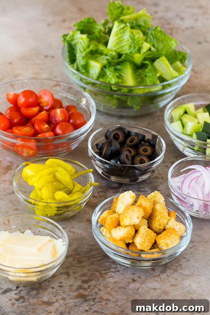 Fresh Italian Salad Ingredients A collection of salad ingredients: fresh lettuce, vibrant cherry tomatoes, crisp cucumber, thinly sliced red onion, briny olives, and golden croutons, ready for assembly.