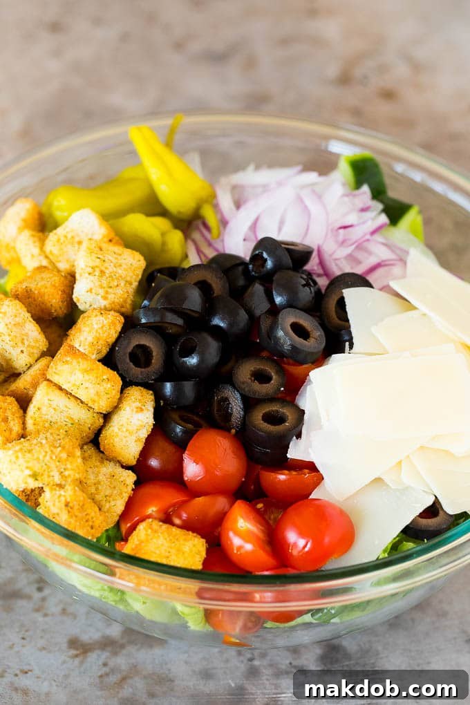 Vibrant Italian Salad Medley A large bowl filled with vibrant Italian salad, showcasing crisp lettuce, colorful cherry tomatoes, black olives, and shaved Parmesan cheese, topped with crunchy croutons.