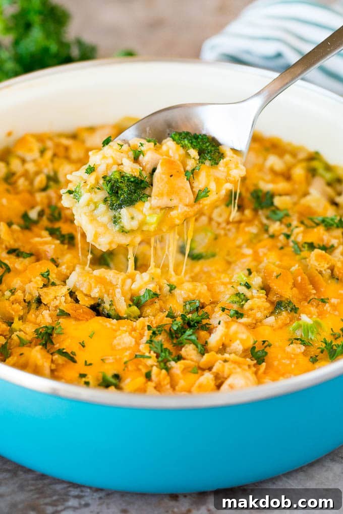 A spoon serving up a portion of cheesy chicken broccoli casserole.